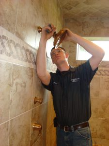 Plumber installing a shower fixture.