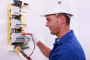 An electrician checking the voltage of a power panel