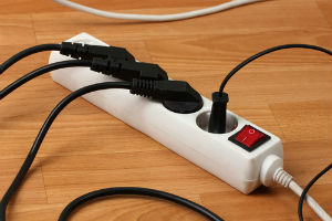 Power strip on the floor maxed out with cords