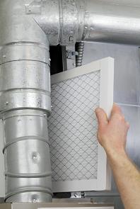 Person chaning the filter on a furnace
