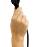 A person holding a black power cord into the air