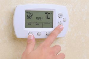 Hand pressing down on the thermostat