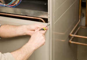 Focused view on HVAC technician's hands as they service a boiler
