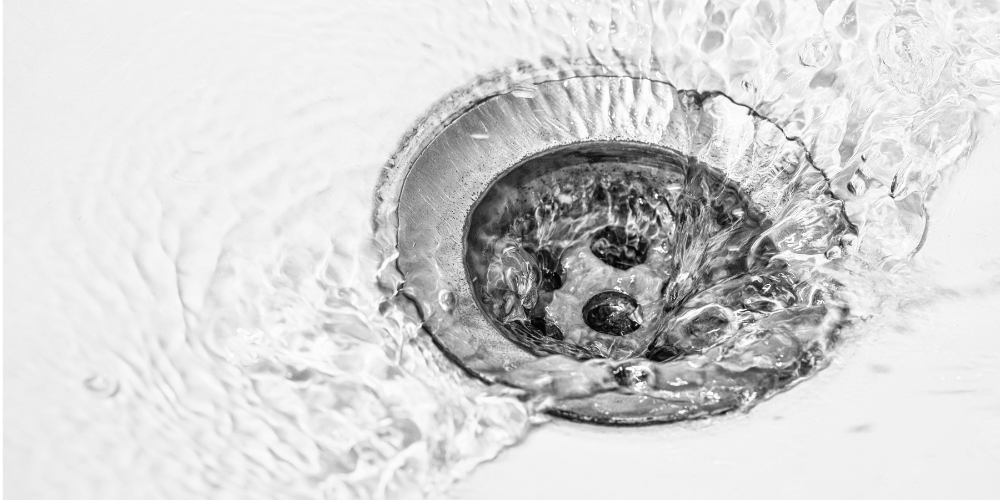 Water flowing into a sink drain - Drain Line vs. Sewer Line Problem: What’s The Difference? - Black Diamond Plumbing & Mechanical